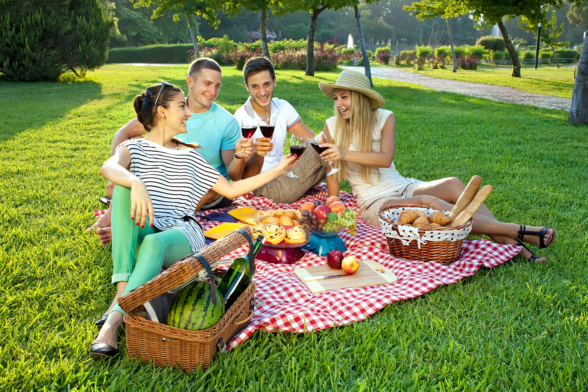 Cuatro jóvenes amigos haciendo un picnic en el parque